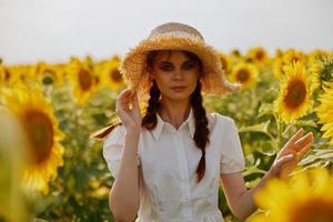 woman with pigtails in a hat on a field of sunflowers landscape photo