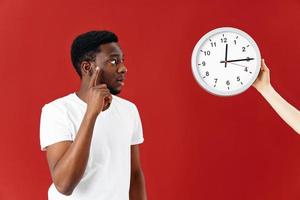 man holding hand near face clock emotions red background studio photo
