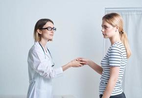 mujer médico y paciente sacudida manos en un ligero antecedentes comunicado medicina foto