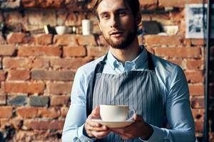 man in apron barista work professional a cup of coffee in hand photo