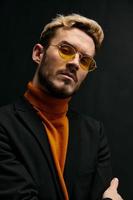 stylish man with glasses orange sweater coat black background confident look photo