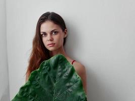 woman hides behind a green file sheet light background photo