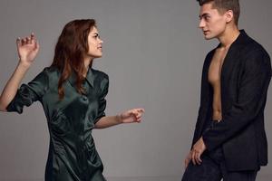 A woman and a man stand opposite on a gray background and gesticulate with their hands photo