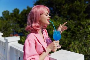 retrato de hermosa mujer con rosado pelo verano cóctel refrescante bebida contento hembra relajante foto