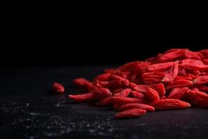 Goji berries on black background. Generate Ai photo