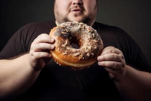 grasa hombre Listo a comer grande rosquilla. generar ai foto