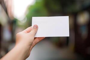 hand holds blank white paper with blurred background. free copy space. photo