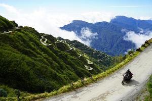 motorista montando en zig zag la carretera de antiguo seda ruta este sikkim foto