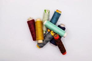 Muticolor sewing threads on white background photo