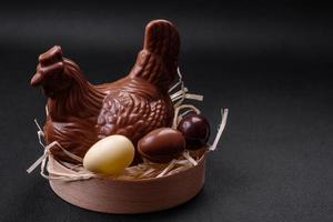 chocolate Pascua de Resurrección gallina y huevos en un nido con Paja foto