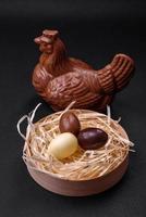 Chocolate Easter hen and eggs in a nest with straw photo