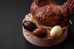 chocolate Pascua de Resurrección gallina y huevos en un nido con Paja foto