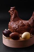 Chocolate Easter hen and eggs in a nest with straw photo