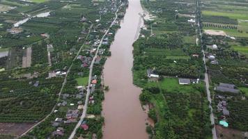 aereo Visualizza di Barche e case allagato nel rurale Tailandia. superiore Visualizza di il fiume fluente dopo pesante pioggia e allagamento nel il villaggio. clima modificare concetto video