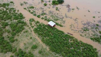 vista aérea de barcos y casas inundadas en las zonas rurales de tailandia. vista superior del río que fluye después de fuertes lluvias e inundaciones en el pueblo. concepto de cambio climático video