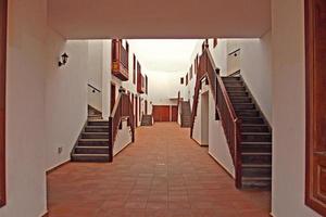 patio with a spanish house with white walls and wooden steps photo