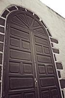 original large wooden brown entrance door to the white church building photo