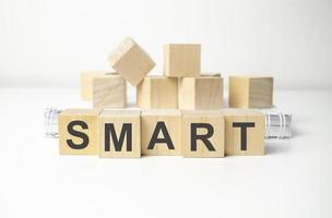 wooden cube block with smart business word on table background. photo