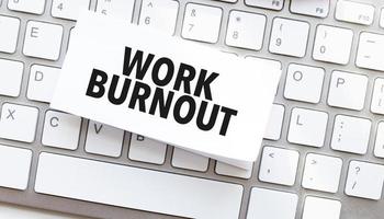 work burnout written on paper sheet on a computer keyboard photo