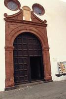 original large wooden brown entrance door to the white church building photo