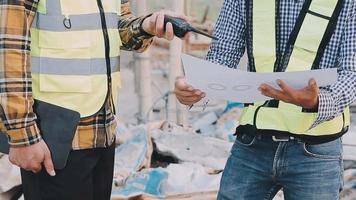 Two Specialists Inspect Commercial, Industrial Building Construction Site. Real Estate Project with Civil Engineer, Investor Use Laptop. In the Background Crane, Skyscraper Concrete Formwork Frames video