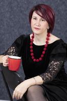 Middle-aged woman with a red cup. photo