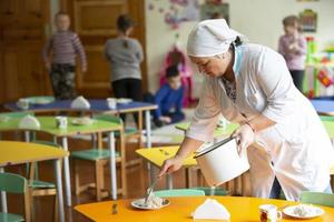 Belarus, the city of Gomel, on 14 December 2017.Open day in kindergarten. Assistant teacher in kindergarten. Nanny in a group of children. photo