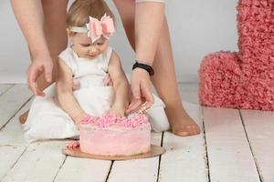 Mom hands and a beautiful baby. Little girl with a birthday cake. photo