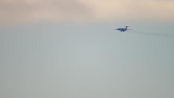 Verkehrsflugzeug im das Himmel fliegt zu Land, lange Schuss, Silhouette. schwer vier Motor Ladung Flugzeug ist fliegend video