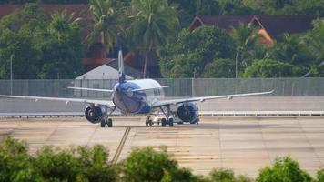 PHUKET, THAILAND NOVEMBER 29, 2019 - GoAir Go Airlines Airbus A320 VT WGB being pushed back by tow truck before departure. View from the top floor of the hotel near airport video