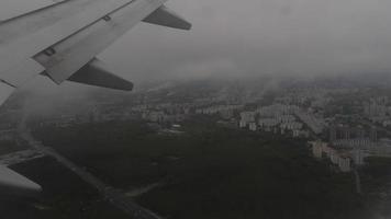 Flugzeug Landung, Wolken von das Bullauge. Flugzeug fliegen Über Stadt. zuerst Person Schüsse von das Bullauge während absteigend video