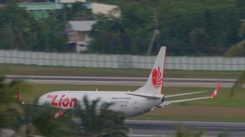 Phuket, Thailand November 26, 2019 - - thailändisch Löwe boeing 737 hs luv Abflug von Phuket Flughafen, wolkig Himmel Hintergrund. Aussicht von das oben Fußboden von das Spritzen Strand Resort Hotel, Phuket, Thailand video