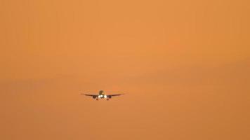 avião a jato se aproximando do pouso em um pôr do sol dourado ardente. conceito de turismo e viagens video