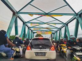 Bekasi, Indonesia in July 2022. The traffic jam that occurred on the steel bridge in Tambun Utara Bekasi, this bridge crosses the Bekasi River. photo