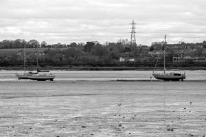 Yachts standing on riverbed flats at low tide photo