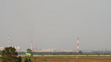 NOVOSIBIRSK, RUSSIAN FEDERATION JUNE 10, 2020 - Long shot, a S7 plane picks up speed on the runway at Tolmachevo International Airport, Novosibirsk. Departing airline S7 video