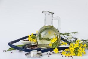 rapeseed oil seeds and flowers with stethoscope photo