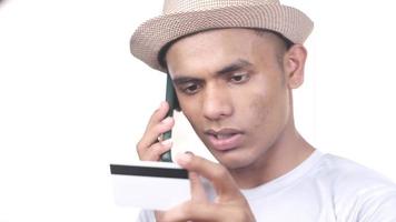 homem mão segurando crédito cartão e falando em inteligente telefone isolado em branco video