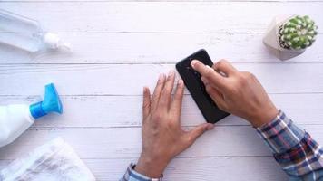 Mens veeg slim telefoon oppervlakte met antibacteriële vloeistof voor voorkomen virus video