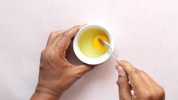 Beating eggs in a glass bowl. Mix egg yolks and whites with a spoon video