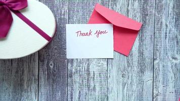 thank you message, envelope and rose flower on wooden table video