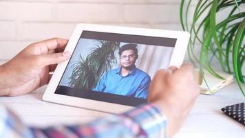 zakenman Holding digitaal tablet bespreken ideeën in video conferentie