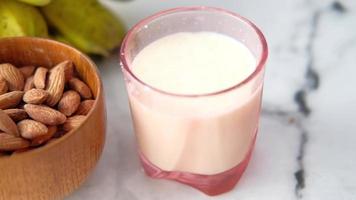 fresh almond nut and glass of milk on table video