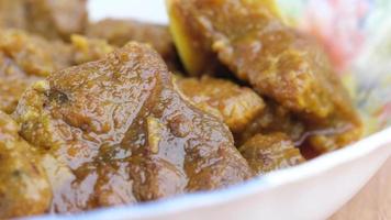 Traditional Indian curry lamb masala in a bowl on table. video