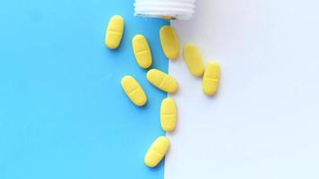 Close up of many vitamin pills on color background video