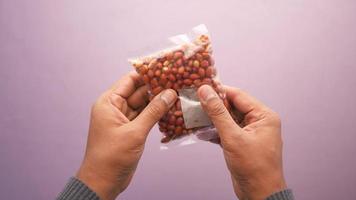 worker holds in his hands a package with peanuts video