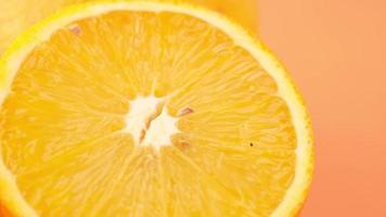 Close up of slice of orange fruit on color background video