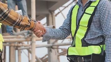 Two business man construction site engineer. Engineering objects on workplace with partners interacting on background video