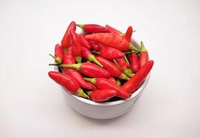 Chili peppers or Cayenne pepper or Cabe rawit in a bowl isolated on white background. photo