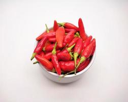 Chili peppers or Cayenne pepper or Cabe rawit in a bowl isolated on white background. photo